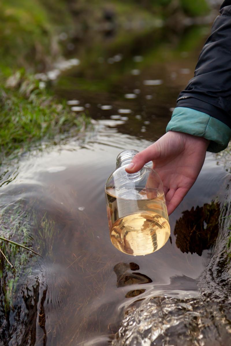 Image of a water sample being taken from a river 